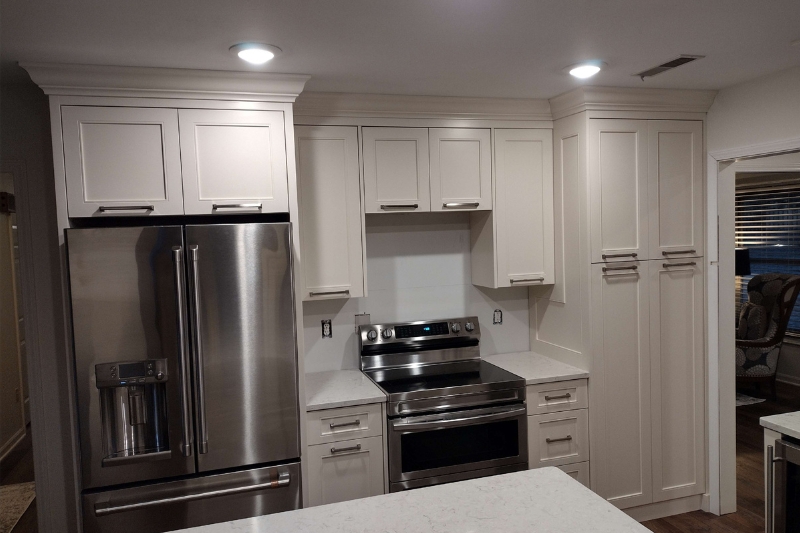 Custom off-white kitchen cabinetry and modern stainless steel appliances installed during a residential kitchen remodeling project.